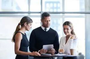A group of businesspeople using a digital tablet together in an office