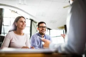 Young happy couple communicating with their financial advisor on a meeting in the office.