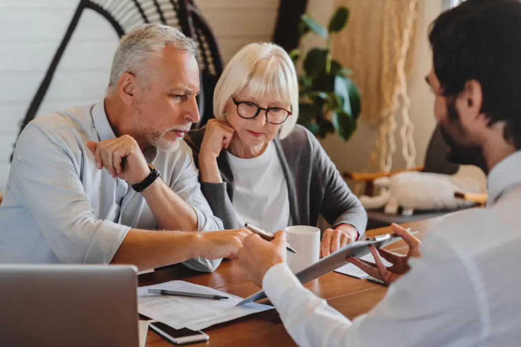 Two older adults being shown a screen by an associate