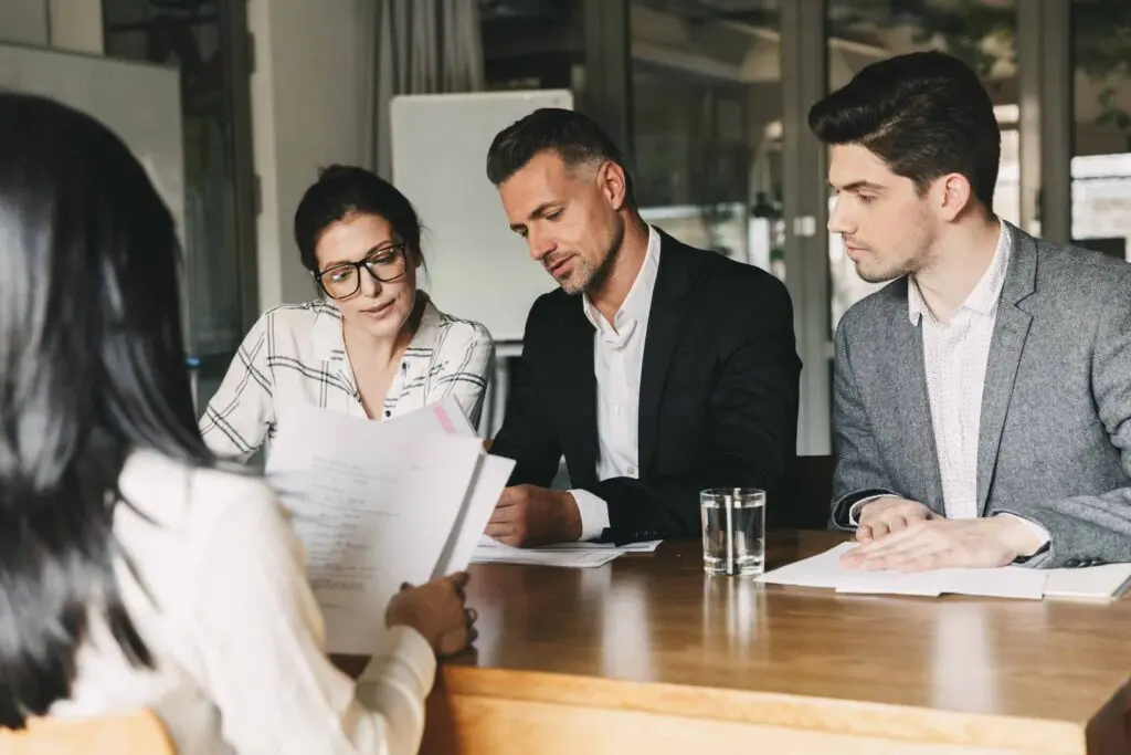 Family of three in a meeting looking at paper work with an associate across from them