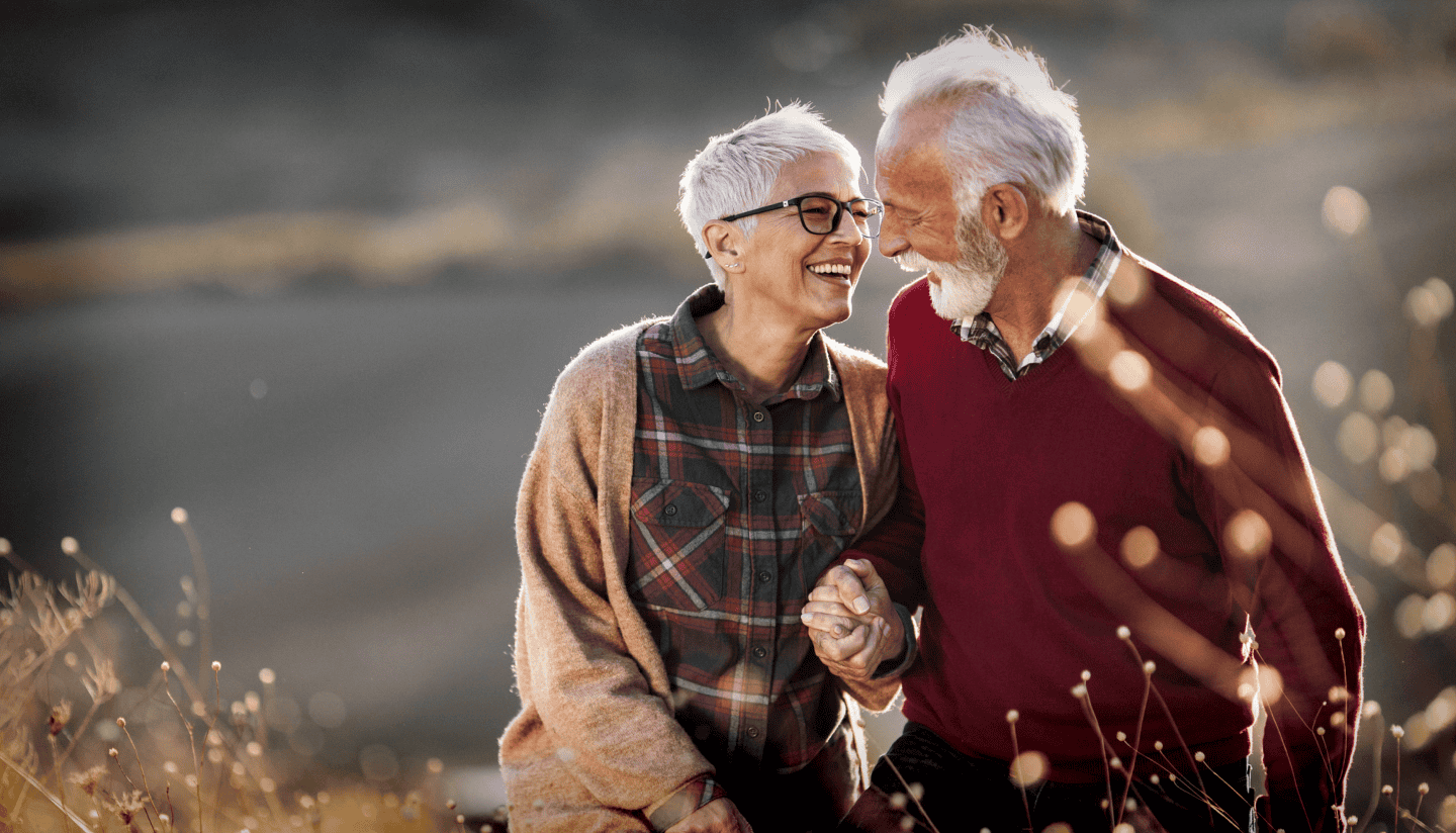 An older couple lovingly hold hands