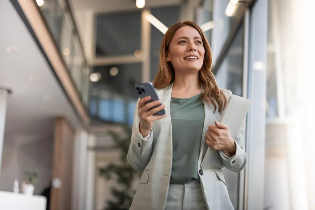 Smiling businesswoman using phone in office