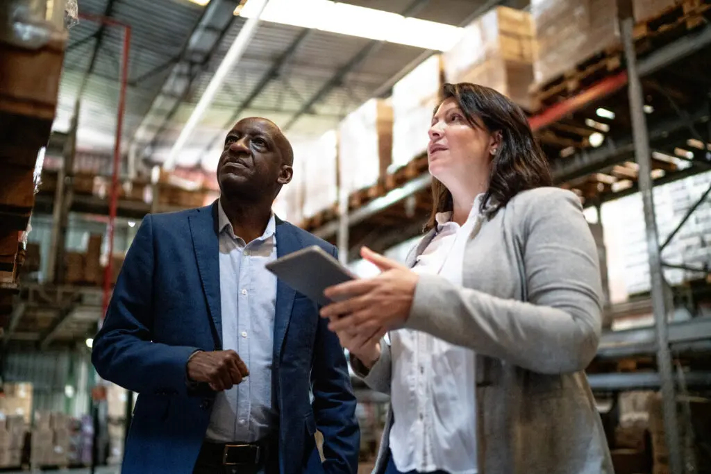 Coworkers talking while walking in a warehouse
