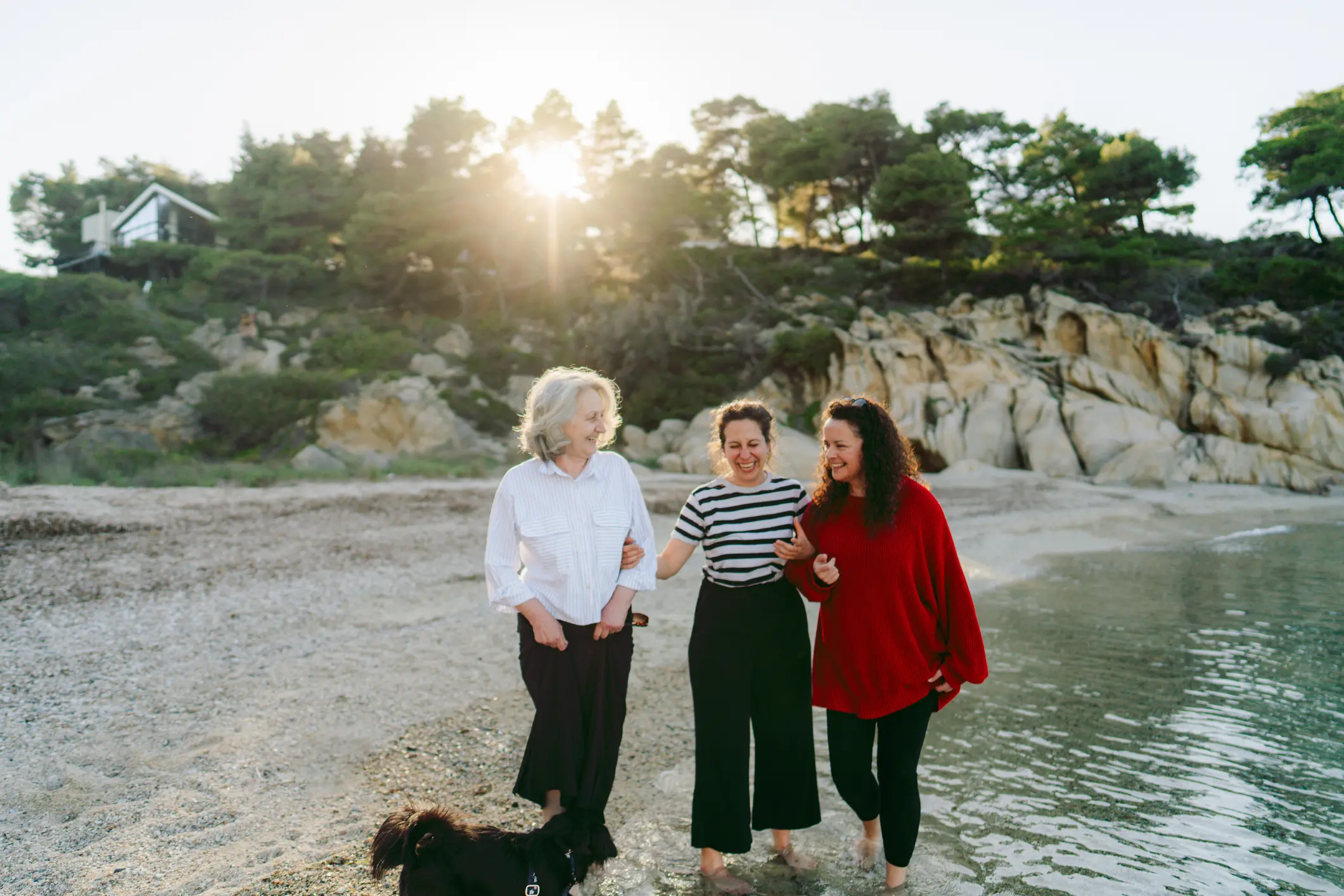 Photo of a senior woman and her adult children, walking down the beach, sharing stories and memories and enjoying quality time together