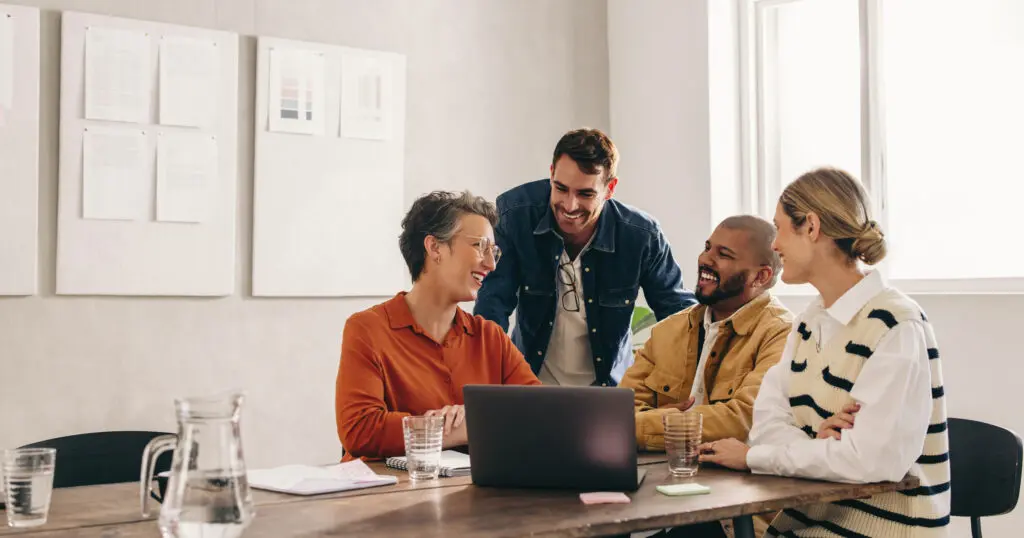Cheerful designers smiling happily while having a meeting in an office. Group of successful businesspeople working on a new interior design project in a creative workplace.