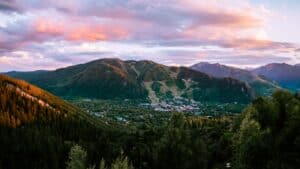 A shot from a lush green mountain top looking down into the city of Aspen