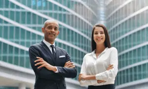 Two business professionals crossing arms looking at camera