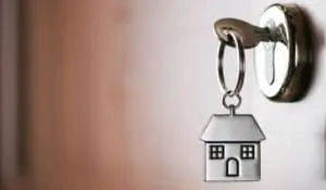 image of a key in the door with a small metallic keyring in the shape of a house