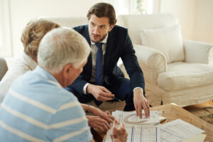 Man in suit meeting with an elderly couple to discuss naming a corporate trustee