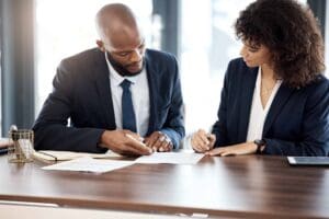 Well dressed couple holding pens and reading over a document