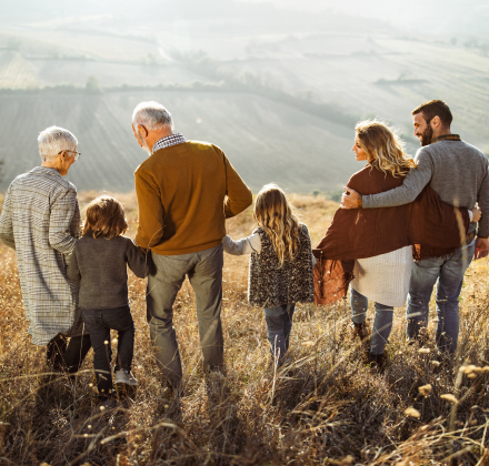 Multigenerational family walking in a field at golden hour