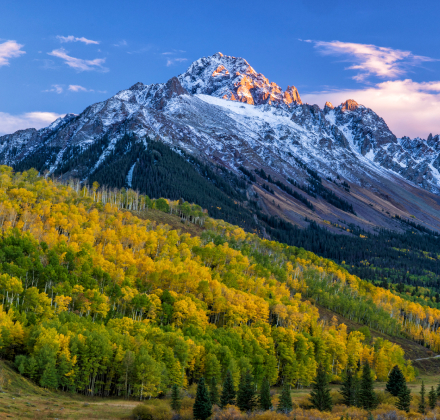 Maroon Bells in the fall with aspens that have leaves that are green and yellow