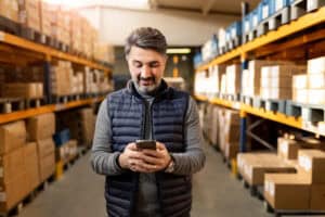 Entreprenuer working in factory warehouse.