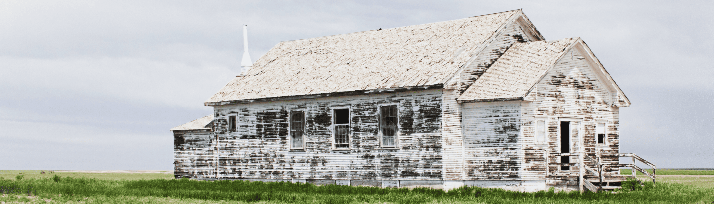 A worn white painted house on the range, from the First Western Trust art collection.