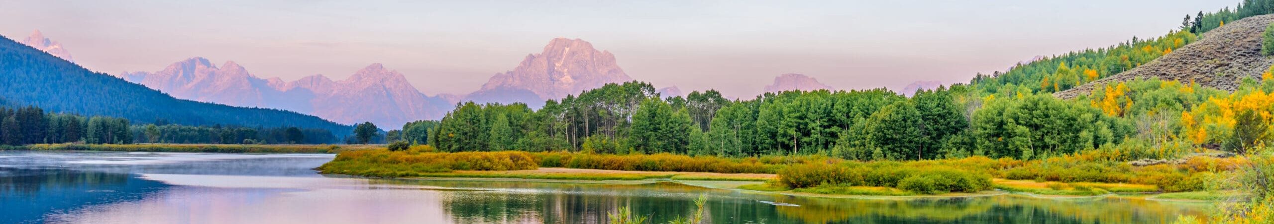 Mount Moran bathed in the soft glow of sunrise and reflected in the still waters of the Snake River is nature’s quiet masterpiece unfolding in perfect symmetry. This scene was photographed from Oxbow Bend in Grand Teton National Park near Jackson, Wyoming, USA.